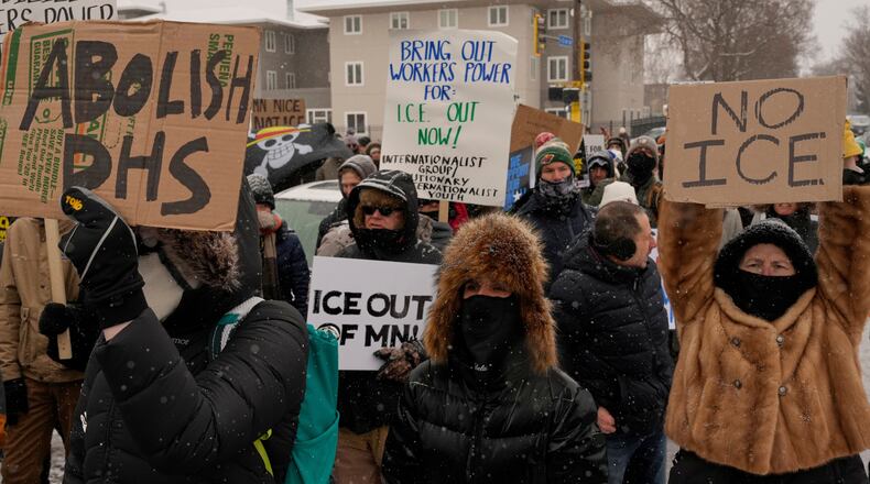 People gather near the post office during a protest, Sunday, Jan. 18, 2026, in Minneapolis. (AP Photo/Yuki Iwamura)