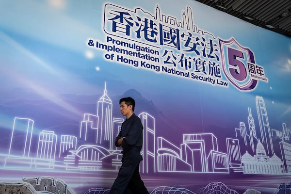 A pedestrian walks past a banner celebrating the 5th Anniversary of the implementation of Hong Kong National Security Law in Hong Kong, Saturday, June 21, 2025. (AP Photo/Chan Long Hei)