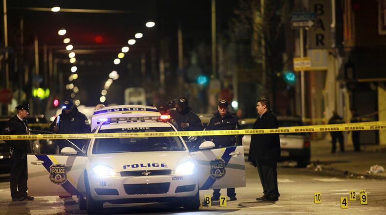 Officials investigate the scene of a shooting Friday, Jan. 8, 2016, in Philadelphia. A Philadelphia police officer was shot multiple times by a man who ambushed him as he sat in his marked police cruiser, authorities said. (AP Photo/Joseph Kaczmarek)