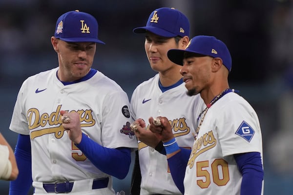 Los Angeles Dodgers' Freddie Freeman, left, Shohei Ohtani, center, and Mookie Betts pose with their rings during a World Series Champion ring ceremony prior to a baseball game against the Detroit Tigers, Friday, March 28, 2025, in Los Angeles. (AP Photo/Mark J. Terrill)
