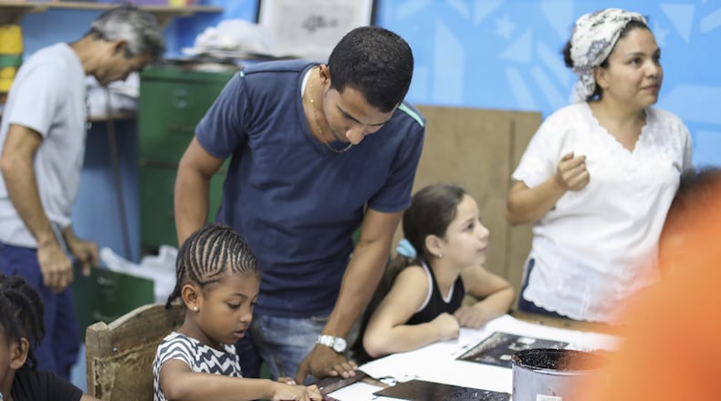 London Wyche (center) a third grader at the Green School, and Raquel Paulino, the school’s director (right) work on projects with staff and students from the Muraleando community arts center in Havana. The immersion school in East Point recently sponsored a trip to Cuba.