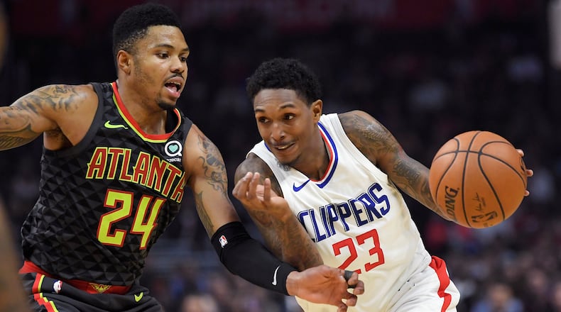 Los Angeles Clippers guard Lou Williams, right, drives by Atlanta Hawks guard Kent Bazemore during the second half of a basketball game, Monday, Jan. 8, 2018, in Los Angeles. The Clippers won 108-107. (AP Photo/Mark J. Terrill)