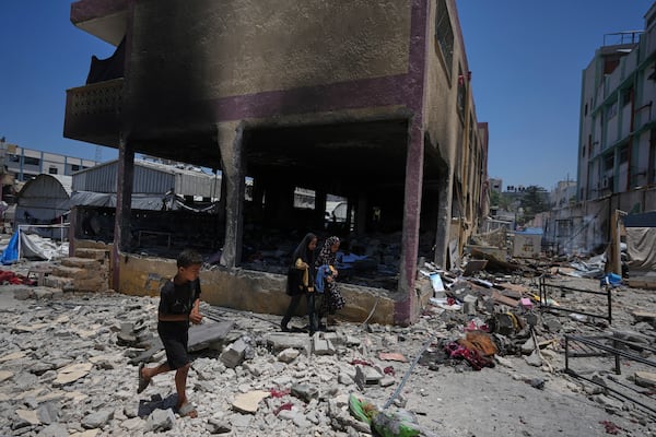 Palestinians survey the destruction at a school used as a shelter after it was struck by an Israeli airstrike in Gaza City, on Thursday, July 3, 2025. (AP Photo/Jehad Alshrafi)