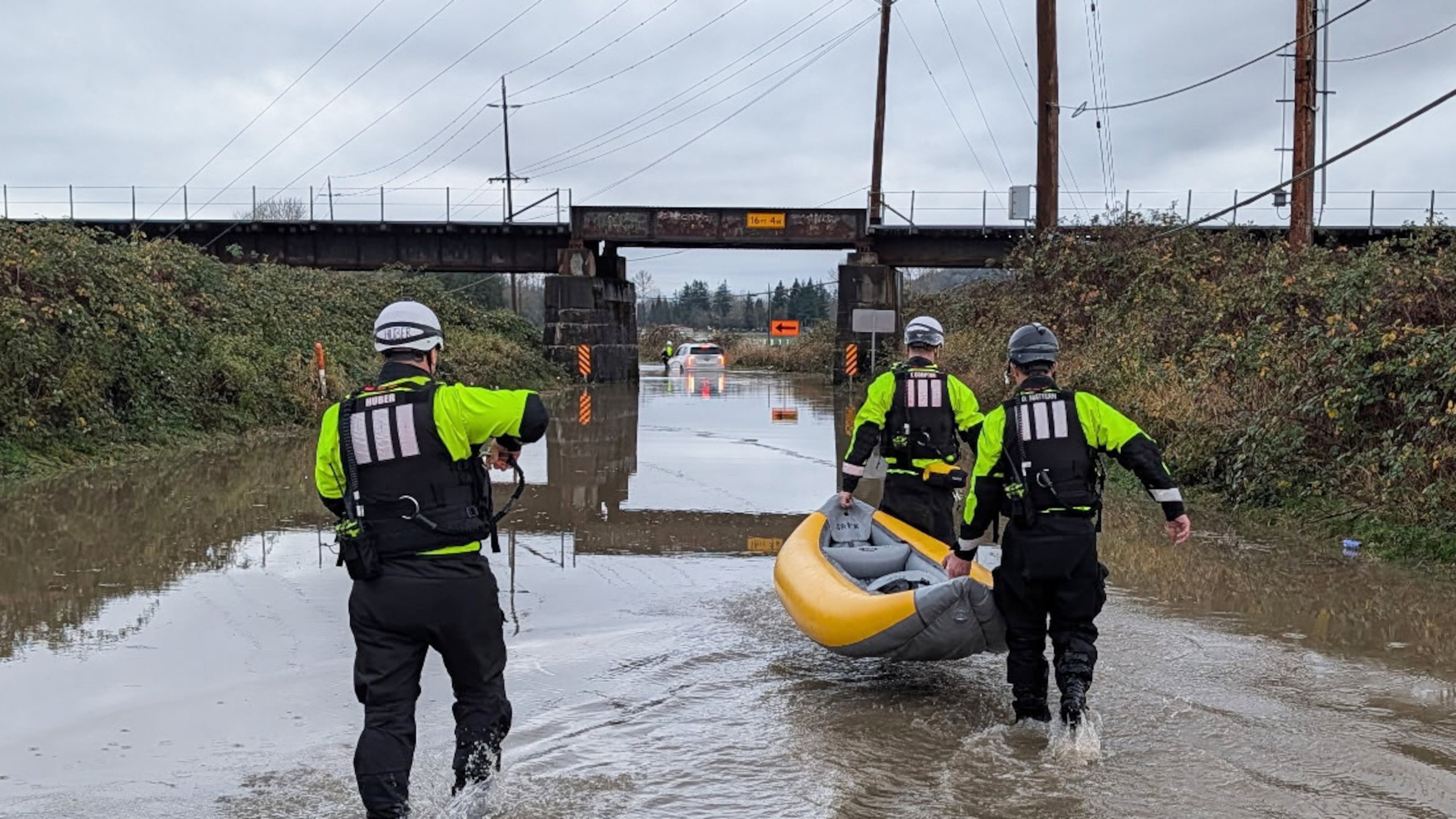 This photo provided by Snohomish Regional Fire & Rescue shows a crew using an inflatable kayak to rescue two people from a vehicle that was stranded by floodwaters, Tuesday, Dec. 9, 2025, in Snohomish, Wash. (Snohomish Regional Fire & Rescue via AP)