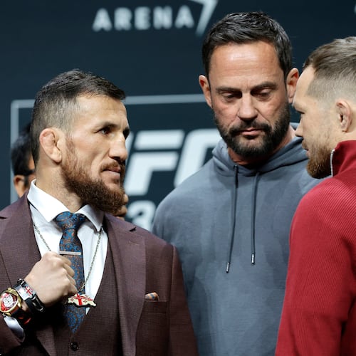 UFC bantamweight champion Merab Dvalishvili, left, of Georgia, faces off with challenger Petr Yan, of Russia, as UFC matchmaker Mick Maynard looks on during a news conference promoting UFC 323, Thursday, Dec. 4, 2025, in Las Vegas. (Steve Marcus/Las Vegas Sun via AP)