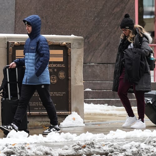 Pedestrians walk on the sidewalk during a cold day in Chicago, Tuesday, Nov. 11, 2025. (AP Photo/Nam Y. Huh)