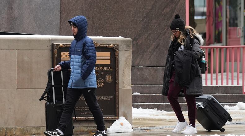 Pedestrians walk on the sidewalk during a cold day in Chicago, Tuesday, Nov. 11, 2025. (AP Photo/Nam Y. Huh)