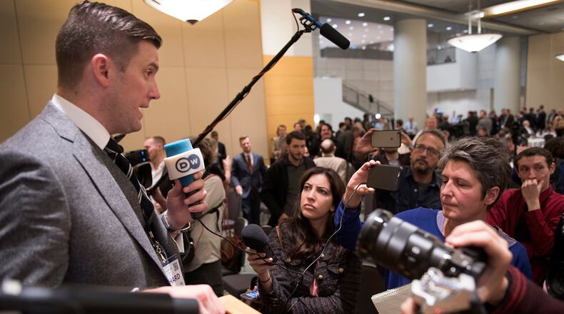 In this Nov. 18, 2016, photo, Richard Spencer, left, talks to the media at an Alt Right conference hosted by the National Policy Institute in Washington. CNN and host Jake Tapper have both apologized for an on-screen banner that Tapper said was "unacceptable" and "horrified" him when it appeared during his show on Monday, Nov. 21, 2016. The offending phrase appeared during a discussion among Jim Sciutto, subbing for Tapper on "The Lead," and two journalists about President-elect Donald Trump's support from the alt-right. The segment focused on white nationalist leader Spencer, whose anti-Semitic declarations Sciutto characterized as "hate-filled garbage." (Linda Davidson/The Washington Post via AP)