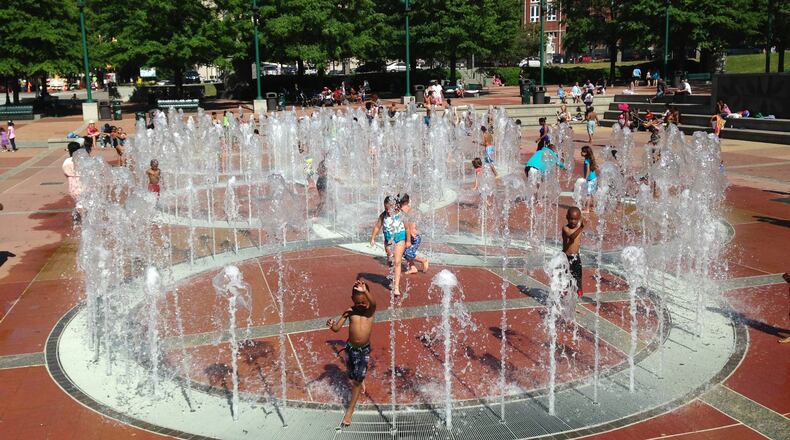 Children running and playing through the fountain rings