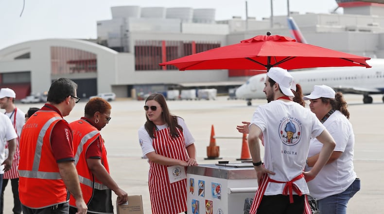 August 8, 2019, 2019 - Atlanta - Catherine Sirna (center), a Delta employee, takes ice cream orders out on the tarmac. After a hot summer of heaving heavy bags at the world’s busiest airport, Delta thanked its baggage handlers with cold drinks, ice cream and juice bars at an end-of-summer event on the tarmac Thursday. Bob Andres / robert.andres@ajc.com