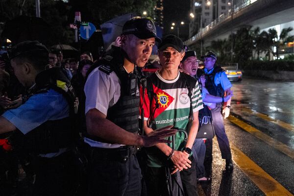A man, right, is detained by police officers at the Victoria Park, the city's venue for the annual 1989 Tiananmen massacre vigil, on the 36th anniversary of China's Tiananmen Square crackdown, in Hong Kong, Wednesday, June 4, 2025. (AP Photo/Chan Long Hei)