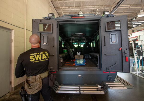Benjamin Griggs strides across the South Fulton station his team reports from and opens up the heavy doors to the back of a BearCat. 