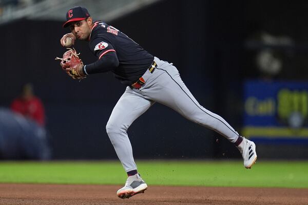 Cleveland Guardians shortstop Brayan Rocchio throws to first too late, as San Diego Padres' Brandon Lockridge arrives safely to first for a single during the fifth inning of a baseball game Tuesday, April 1, 2025, in San Diego. (AP Photo/Gregory Bull)