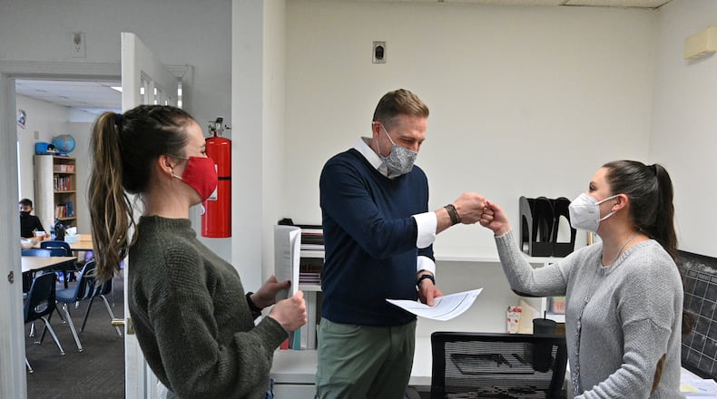 February 16, 2022 Norcross - Scott Mawdesley (center), Vice President of Corners Outreach, fist bumps Cinthia Valdez, program director, as Carrie Schneider (left), program director, looks during after school tutoring program at Corners Outreach in Norcross on Wednesday, February 16, 2022. To address pandemic learning loss, Gwinnett County Public Schools will bring in Corners Outreach and more than 30 other tutoring providers to work with students who need additional help with school coming back from virtual learning. (Hyosub Shin / Hyosub.Shin@ajc.com)