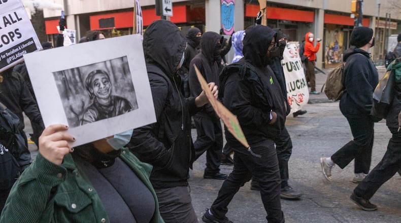 Forest Defender protesters march in the streets near Underground Atlanta Saturday, Jan. 21, 2023. Atlanta Police Department said several people were arrested after a Police car was set afire.