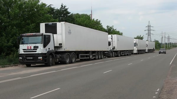 In this photo, taken from video distributed by Russian Defense Ministry Press Service on Sunday, June 8, 2025, the motorcade of refrigerators of the first convoy carrying bodies of Ukrainian soldiers for repatriation is parked at an exchange area near Novaya Guta, Belarus, for the beginning of a large-scale exchange between Russia and Ukraine. (Russian Defense Ministry Press Service via AP)