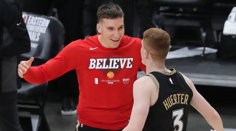 Bogdan Bogdonovic and Kevin Huerter celebrate the Hawks' big win over the Bucks Tuesday.