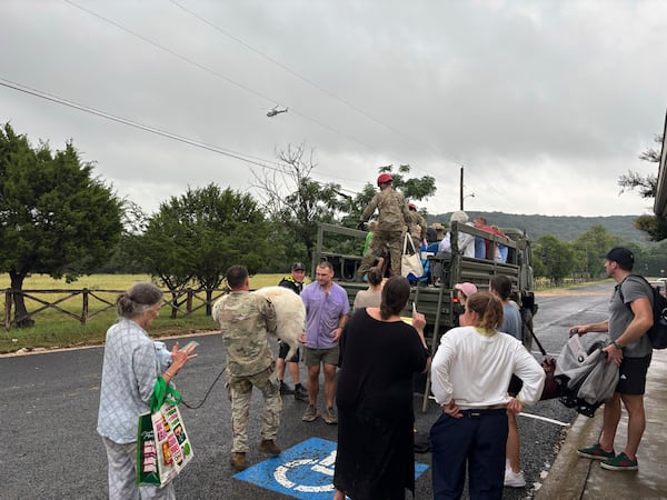 Residents prepare for transport away from Hunt, Texas, at 6:26 p.m. on Friday, July 4, 2025, after floodwaters from the Guadalupe River devastated their town. (Shabd Simon-Alexander via AP)