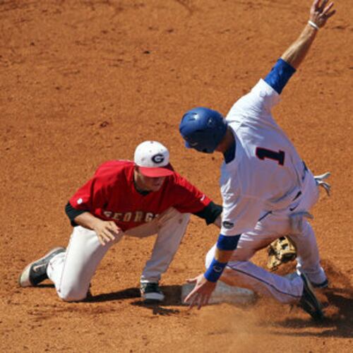 Shortstop Kyle Farmer (left), from back in his UGA days, tags out Florida's Bryson Smith who is caught stealing in the seventh inning. (AJC 2011)