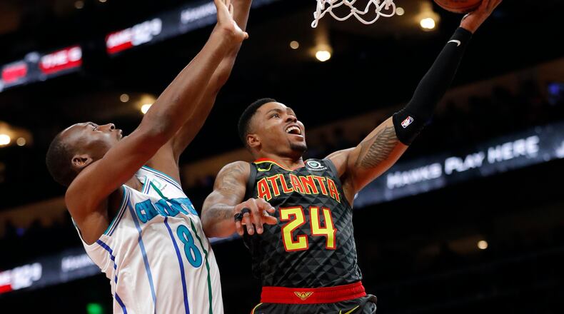 Atlanta Hawks guard Kent Bazemore (24) scores as Charlotte Hornets center Bismack Biyombo (8) defends during the first half of an NBA basketball Saturday, Feb. 9, 2019, in Atlanta. (AP Photo/John Bazemore)