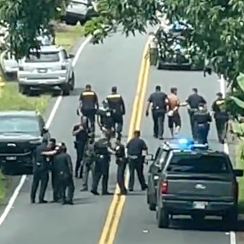 Police arrest a man accused of multiple killings, right, on Thursday, May 28, 2026, in Kaimu, Hawaii. (Deborah Davis via AP)