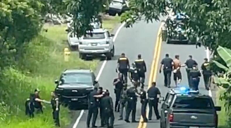 Police arrest a man accused of multiple killings, right, on Thursday, May 28, 2026, in Kaimu, Hawaii. (Deborah Davis via AP)