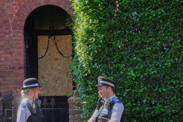 Police Community Support Officers stand near the fire damaged doorway of a house belonging to British Prime Minister Keir Starmer in Kentish Town in London, Tuesday, May 13, 2025. (AP Photo/Kirsty Wigglesworth)