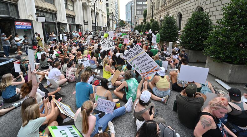 People "play dead" outside the U.S. Court of Appeals building as they protest the Supreme Court's decision to overturn Roe v. Wade in downtown Atlanta on Saturday, June 25, 2022. Some expect confusion and conflict on college campuses when students return for the fall semester. (Hyosub Shin / Hyosub.Shin@ajc.com)
