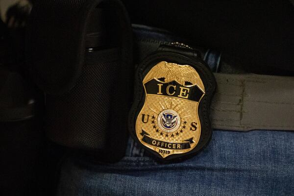 A federal agent wears a U.S. Immigration and Customs Enforcement badge in New York. (Yuki Iwamura/AP 2025)
