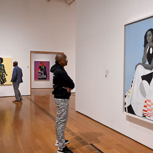 A visitor looks at Amy Sherald's “Michelle Obama” in the “American Sublime” exhibition at the High Museum of Art on Friday, May 15, 2026, in Atlanta. Obama has spent years being subjected to racist and sexist attacks, guest columnist Tymia Ballard writes. (Hyosub Shin/AJC)
