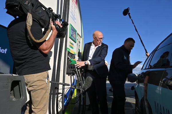 Leader of the Australian opposition Liberal party Peter Dutton, center, assists fueling a car in Melbourne on Wednesday, April 30, 2025. (Mick Tsikas/AAP Image via AP)
