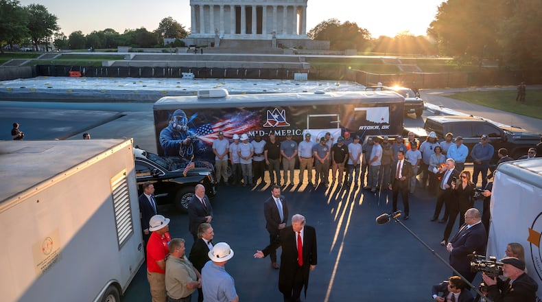President Donald Trump talks as he visits the Lincoln Memorial Reflecting Pool to see the new blue protective coating being applied as part of a renovation project, Thursday, May 7, 2026, in Washington. (AP Photo/Mark Schiefelbein)