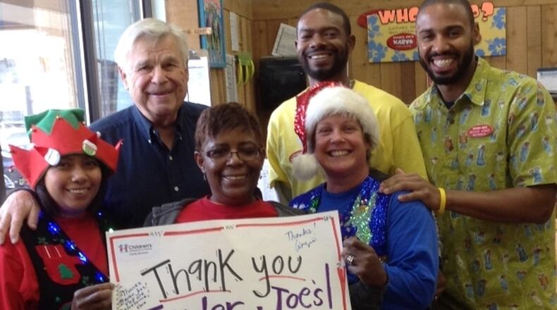 Tom Umstead is shown with Trader Joe’s staffers. The grocery store donates flowers and other items through Mr. Tom’s Heart charity to be given away to nonprofit organizations. CONTRIBUTED BY MR. TOM’S HEART