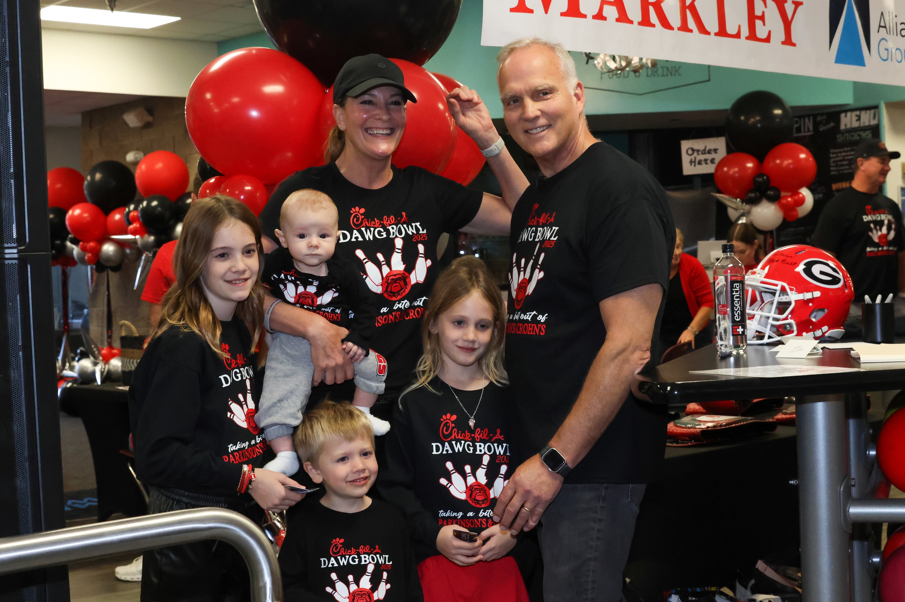 Former UGA football coach Mark Richt poses for a photo with his wife Katharyn and four of their grandchildren during the third annual Chick-fil-A Dawg Bowl fundraiser for Parkinson’s and Crohn’s disease research at Showtime Bowl in Athens on Wednesday, Oct. 22, 2025. Richt, who was diagnosed with Parkinson’s disease in 2021, hosted the event. (C.J. Bartunek for the AJC)