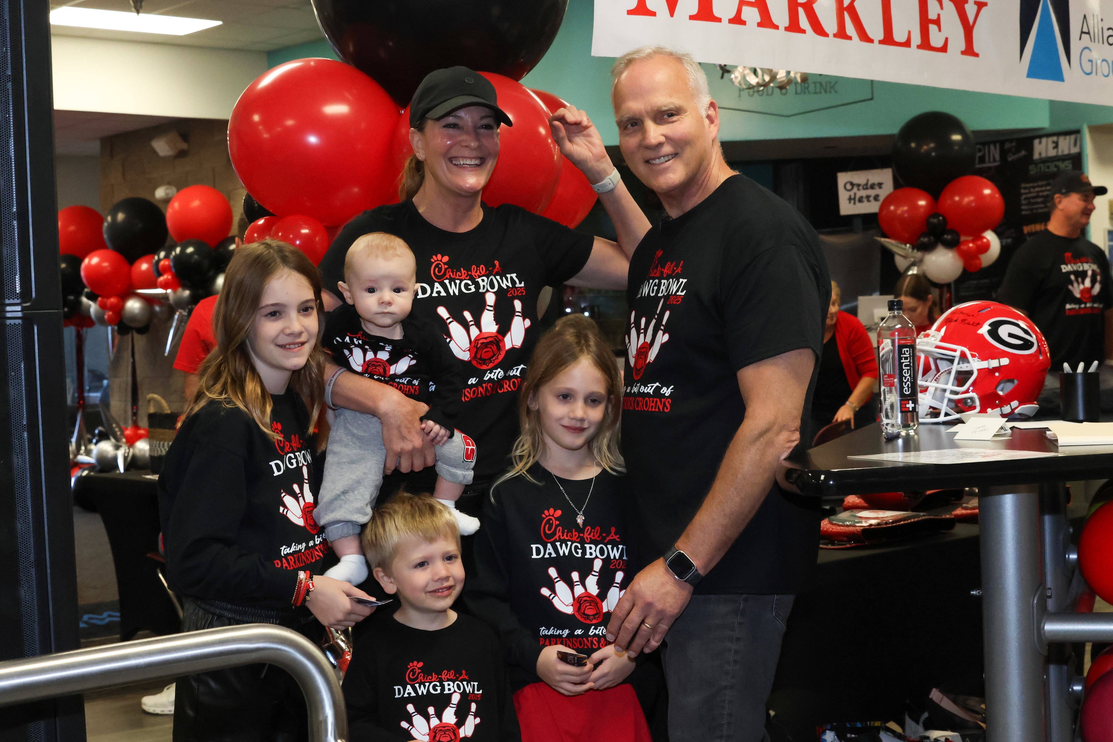 Former UGA football coach Mark Richt poses for a photo with his wife Katharyn and four of their grandchildren during the third annual Chick-fil-A Dawg Bowl fundraiser for Parkinson’s and Crohn’s disease research at Showtime Bowl in Athens on Wednesday, Oct. 22, 2025. Richt, who was diagnosed with Parkinson’s disease in 2021, hosted the event. (C.J. Bartunek for the AJC)