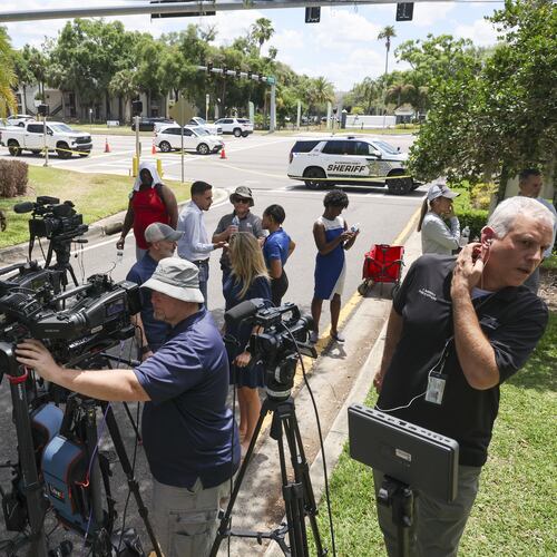 Members of the media document detectives and deputies with the Hillsborough County Sheriff's Office as they investigate inside the Lake Forest subdivision of Tampa, Fla., on Friday, April 24, 2026, where authorities said a man was taken into custody after barricading himself inside a home, in connection to the search for two missing University of South Florida graduate students. (Douglas R. Clifford/Tampa Bay Times via AP)