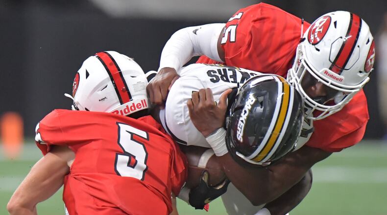 Colquitt County wide receiver Lemeke Brockington (17) is tackled by North Gwinnett's Jack Mcgill (5) and Jared Ivey (15) in the second half of  the Corky Kell Classic Saturday, Aug. 24, 2019, at Mercedes-Benz Stadium.