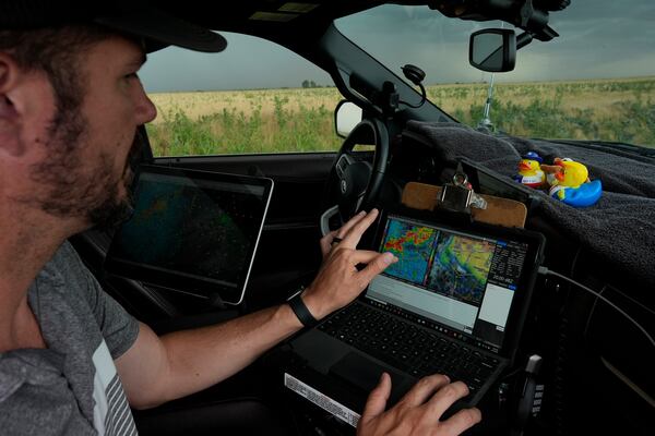 Victor Gensini, Northern Illinois University meteorology professor and a lead scientist of Project ICECHIP, checks storm data in the command vehicle during an operation Tuesday, June 3, 2025, south of Tipton, Okla.(AP Photo/Carolyn Kaster)
