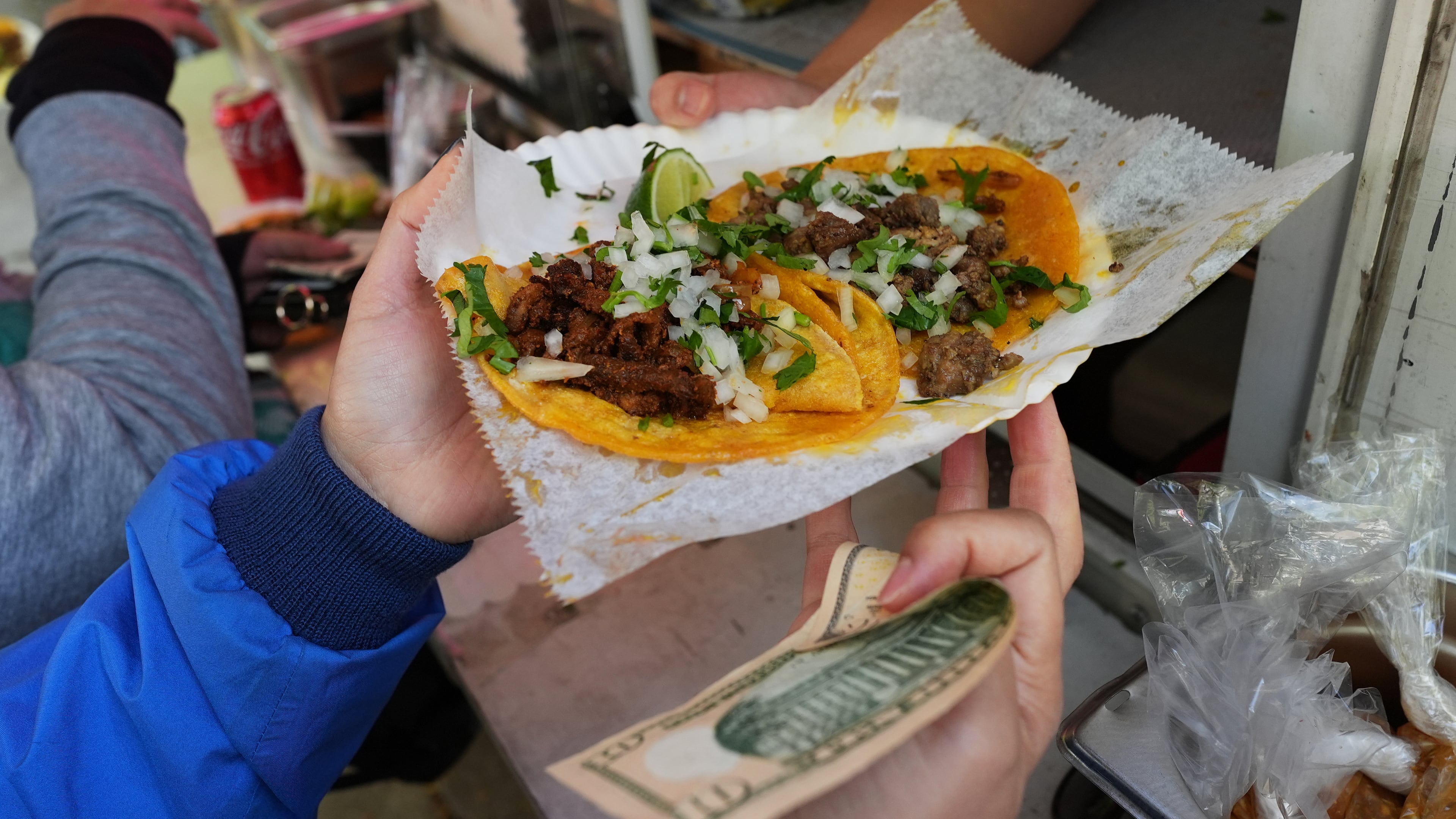 A bicyclist receives food from a street vendor Yulisa Robles, right, at Gage Park during Street Vendor Bike Tour Series, in Chicago, Sunday, Nov. 2, 2025. (AP Photo/Nam Y. Huh)