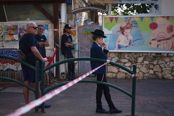 Residents look at the site where an Iranian missile struck in, Haifa, Israel, Monday, June 16, 2025. (AP Photo/Ariel Schalit)