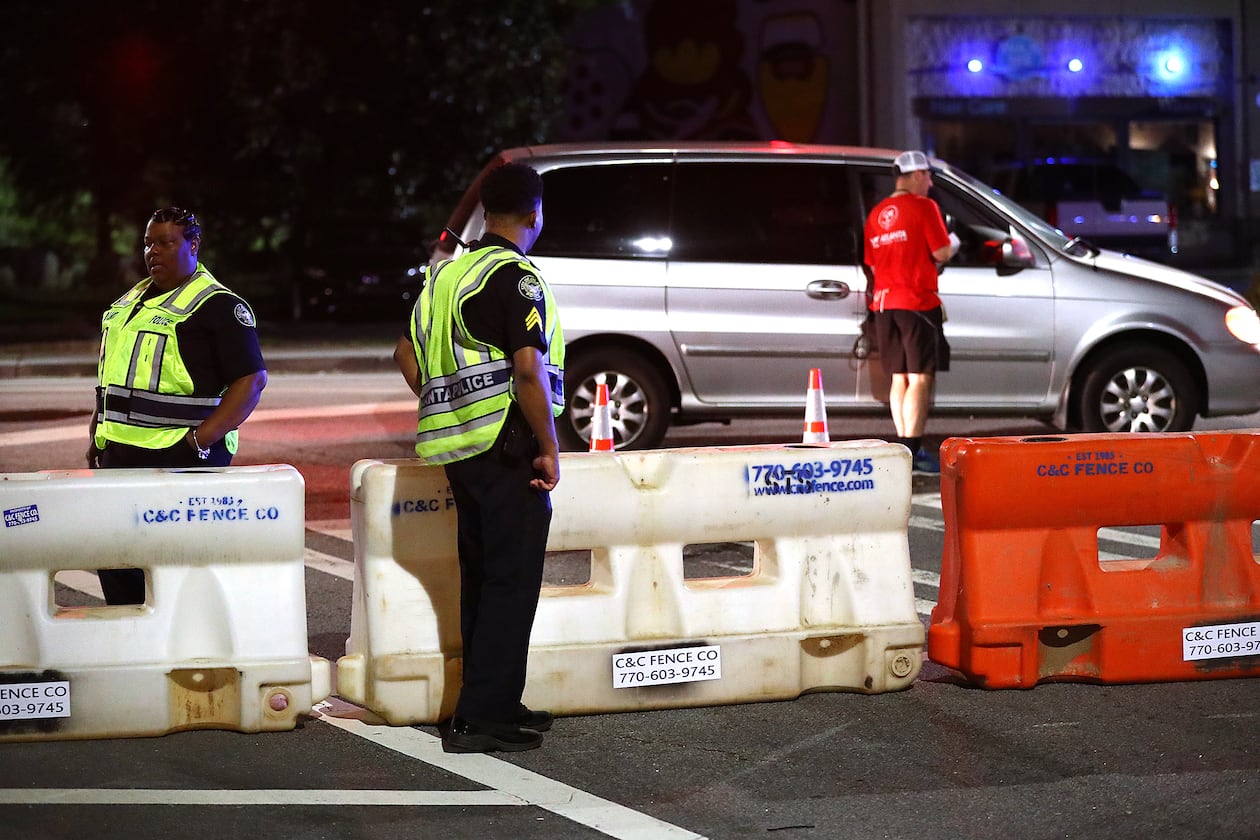 Atlanta police officers man a barricade at 10th Street and Monroe Drive N.E. as roads are shut down for the AJC Peachtree Road Race. (File/AJC 2019)
