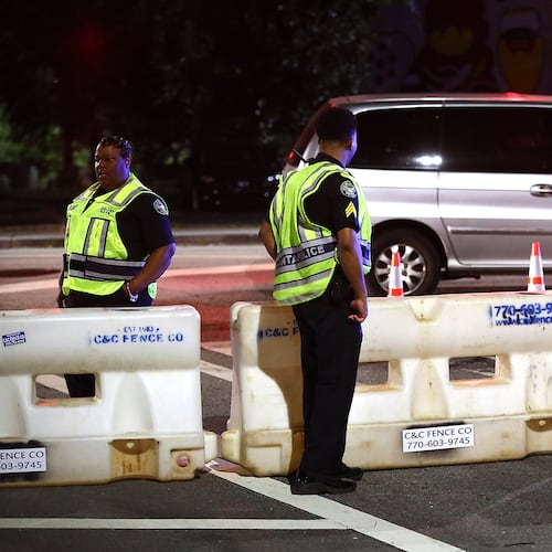 Atlanta police officers man a barricade at 10th Street and Monroe Drive N.E. as roads are shut down for the AJC Peachtree Road Race. (File/AJC 2019)