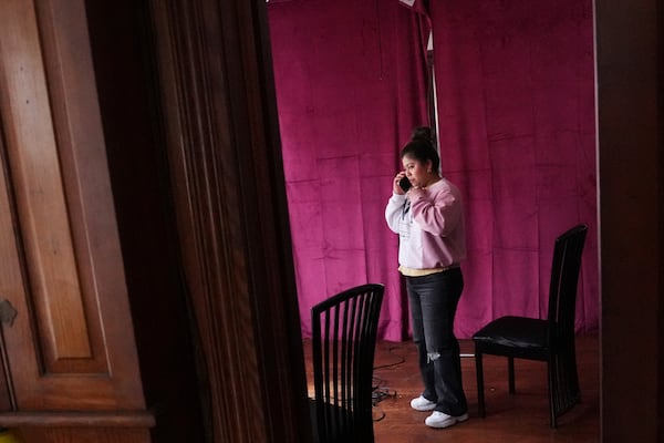 Marilu Domingo Ortiz, whose husband was taken into custody by ICE agents after they smashed a window of their family car, talks on her phone at their home, Wednesday, April 16, 2025, in New Bedford, Mass. (AP Photo/Charles Krupa)