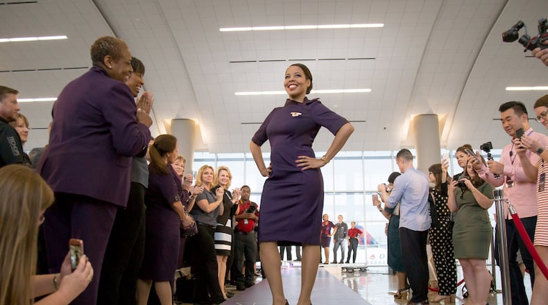 A Delta employee poses for photographs in her new uniform during the Delta Uniform launch at the International Terminal lobby in Atlanta GA Tuesday, May 29, 2018. STEVE SCHAEFER / SPECIAL TO THE AJC