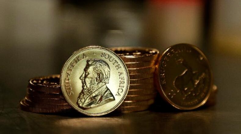 An employee of ProAurum gold house presents the 1 Ounce South African Krugerrand Fine Gold Coin in the safe deposit boxes room in Munich, Germany, Thursday, Dec. 13, 2018.