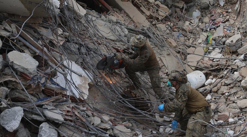 U.S. troops cut through rebar while clearing rubble during a search at a building that collapsed in the twin earthquakes in La Guaira, Venezuela, Tuesday, June 30, 2026. (AP Photo/Ariana Cubillos)