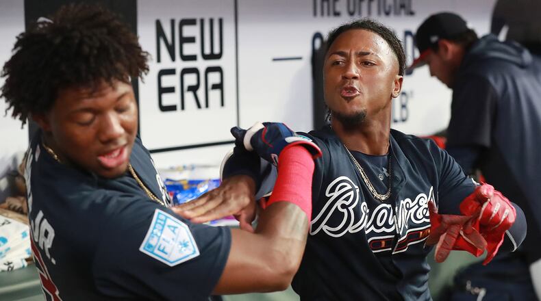 Braves infielder Ozzie Albies gives teammate Ronald Acuna a good-natured shove in the dugout after scoring against the Cincinnati Reds during the second inning on Monday, March 25, 2019, at SunTrust Park in Atlanta.