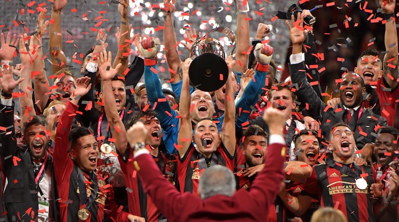 December 8, 2018 Atlanta - Atlanta United midfielder Miguel Almiron (center) raises the MLS Cup as they celebrate after their 2-0 win over the Portland Timbers during the 2018 MLS Cup at Mercedes-Benz Stadium on Saturday, December 8, 2018. HYOSUB SHIN / HSHIN@AJC.COM