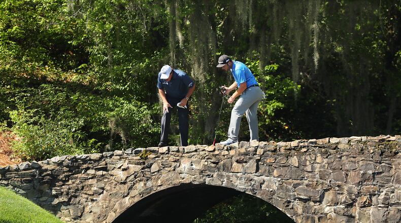 Phil Mickelson and Jon Rahm pause on the bridge to look into the creek along the 13th fairway during their practice round for the Masters at Augusta National Golf Club on Tuesday, April 4, 2017, in Augusta. Curtis Compton/ccompton@ajc.com
