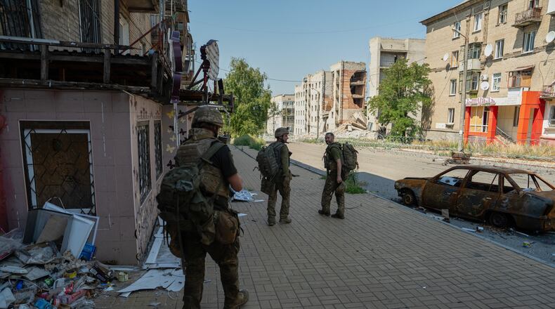 In this photo provided by Ukraine's 93rd Kholodnyi Yar Separate Mechanized Brigade press service and taken Monday, Aug. 10, 2026, Ukrainian soldiers walk along the street in the frontline town of Druzhkivka, Donetsk region, Ukraine. (Iryna Rybakova/Ukraine's 93rd Mechanized Brigade via AP))